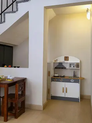 a kitchen with a stove and a table in a room at Kidello Home Ipoh Indoor Private Playground in Ipoh