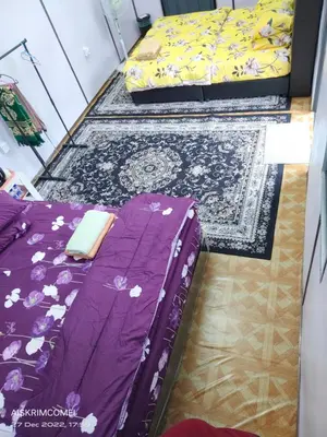 a bedroom with two beds and a rug at Teratak Kasih Kabinstay in Tanjung Karang