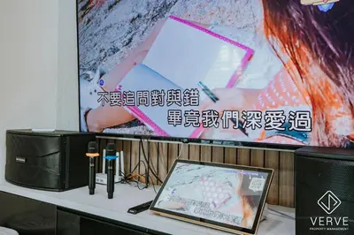 a table with a laptop and a large screen at Ipoh Midtown 33 Funhouse by Verve in Ipoh