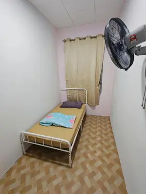 a small room with a bed and a fan at Yoland Homestay Baling Kedah in Baling