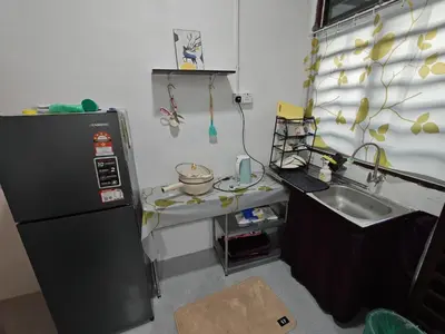 a small kitchen with a sink and a refrigerator at Yoland Homestay Baling Kedah in Baling