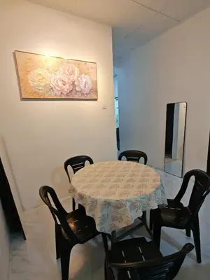 a table and chairs in a room with a painting at Yoland Homestay Baling Kedah in Baling