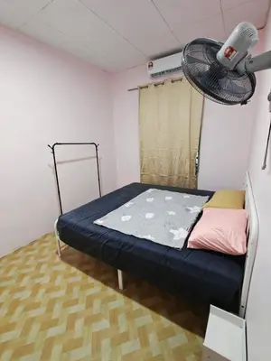 a small room with a bed and a fan at Yoland Homestay Baling Kedah in Baling