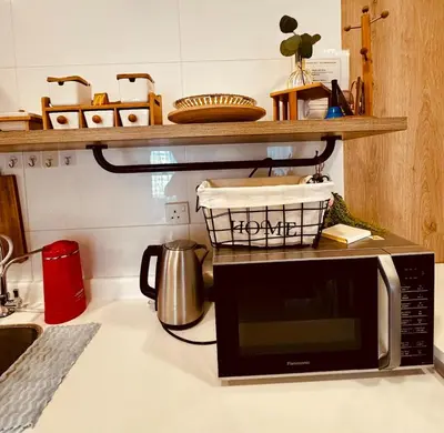 a microwave on a counter with a basket on top of it at Private Apartment in Kuala Lumpur in Gua Sai