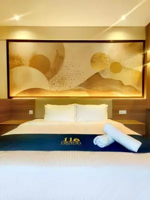a bedroom with a bed with a painting on the wall at 118 Grand Hotel in George Town