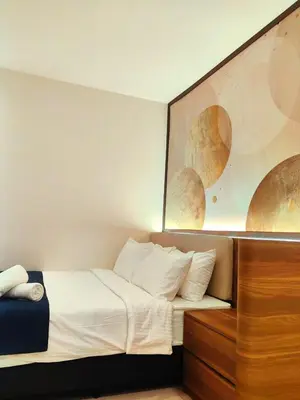 a bed in a hotel room with a painting on the wall at 118 Grand Hotel in George Town