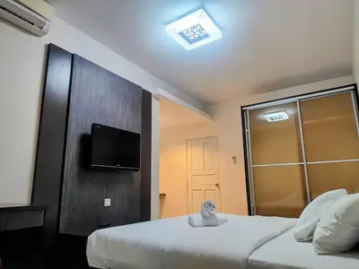 a hotel room with two beds and a television at Kinta Olive in Ipoh