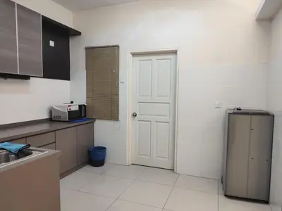 a kitchen with a white door and a refrigerator at Kinta Olive in Ipoh