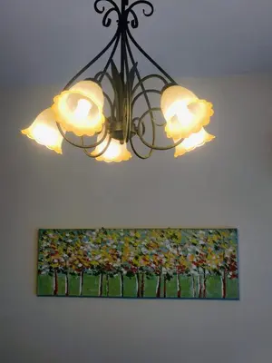 a chandelier hanging from a ceiling with a painting at Kinta Olive in Ipoh