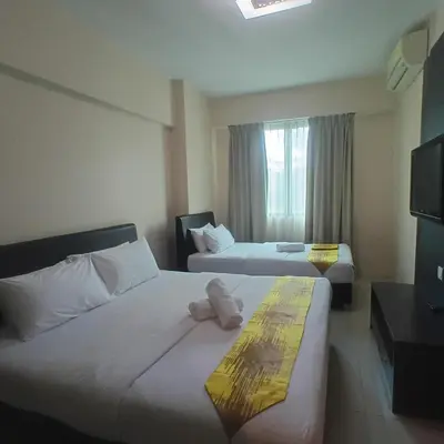 a hotel room with two beds and a television at Kinta Olive in Ipoh