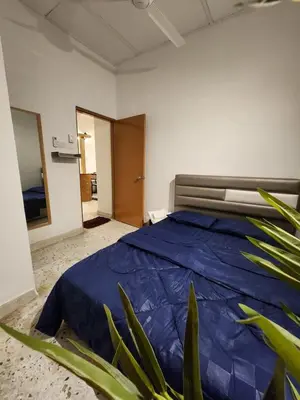 a bedroom with a bed with a blue comforter at Sun Pista Home by Ipoh Maju Stay in Ipoh