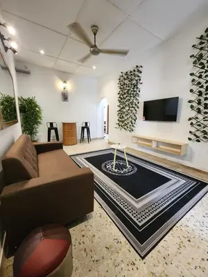 a living room with a couch and a flat screen tv at Sun Pista Home by Ipoh Maju Stay in Ipoh