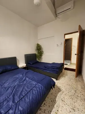 a bedroom with two beds and a door to a room at Sun Pista Home by Ipoh Maju Stay in Ipoh