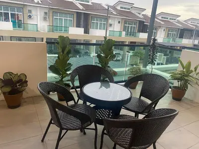 a patio with a table and chairs and a balcony at Sentosa Grand Homestay in Kulim