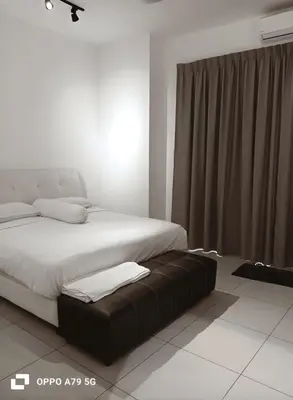 a bedroom with a large bed with a brown ottoman at Sentosa Grand Homestay in Kulim