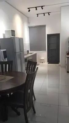 a kitchen with a table and chairs and a refrigerator at Sentosa Grand Homestay in Kulim