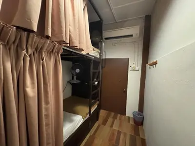 a small room with a bed and a curtain at Hotel London Kuala Lipis in Kuala Lipis
