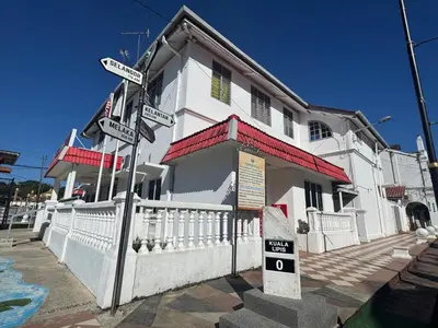 a street sign in front of a white building at Hotel London Kuala Lipis in Kuala Lipis