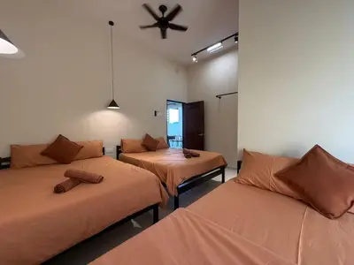 a room with three beds and a ceiling fan at Rustic Vibe Pool Bungalow Karaoke 5R7B for 22pax in Ipoh