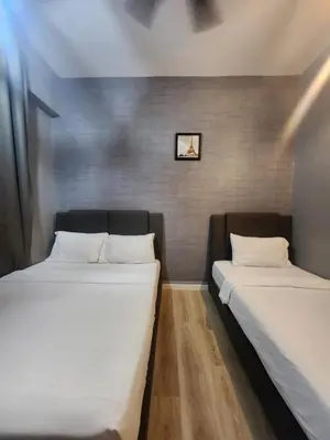 two beds sitting next to each other in a room at The Majestic Condo Ipoh in Ipoh