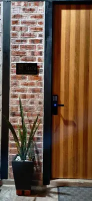 a plant in a pot next to a wooden door at Sekinchan Tiny House in Sekincan