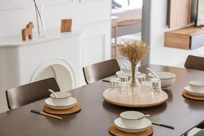 a dining room table with plates and glasses on it at Serene Minimalist Family Retreat 2-7pax 8 min to BoH in Brinchang