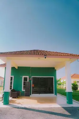 a green house with a green wall and a garage at Wewe Homestay CL2 in Kampung Gajah