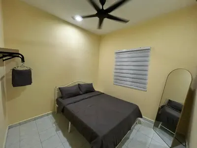 a bedroom with a bed and a ceiling fan at Homestay D'Kampong in Teluk Intan