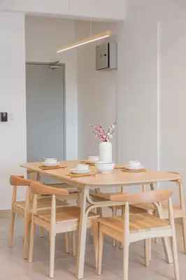 a wooden table with chairs and a dining room at Serene Muji Family Retreat 2-7 pax with Comfortable Living Space in Tanah Rata