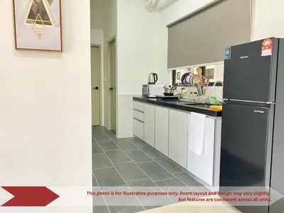 a kitchen with a black refrigerator and white cabinets at The Piccadilly Greentown Residences Ipoh in Ipoh