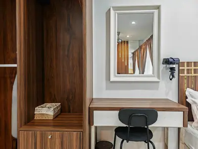 a mirror and a chair in a bedroom at Mansion One Studio VIP Parking Gleneagles Gurney in George Town