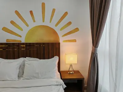 a bedroom with a bed with a sun mural on the wall at Mansion One Studio VIP Parking Gleneagles Gurney in George Town