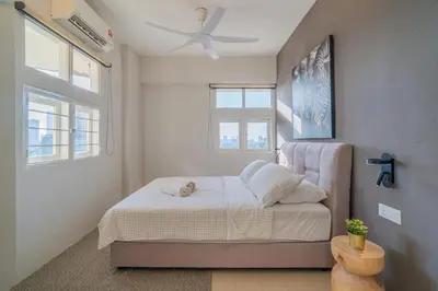 a bedroom with a bed and a ceiling fan at Stylish 3BR Stay Near Gurney Drive Free Parking in George Town