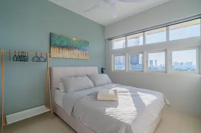 a bedroom with a bed and a painting on the wall at Stylish 3BR Stay Near Gurney Drive Free Parking in George Town