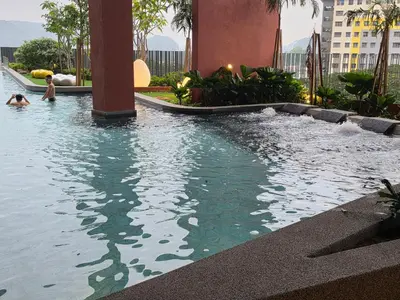 a pool in a building with people in the water at Piccadilly Residence Greentown in Ipoh