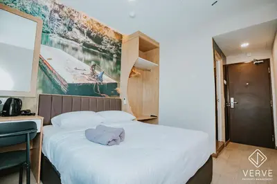 a hotel room with a large bed and a painting on the wall at Ipoh Town Area Avs Hotel by Verve in Ipoh