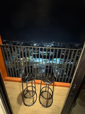 two chairs on a balcony with a view of a city at Piccadilly Greentown by Jun Residence in Ipoh