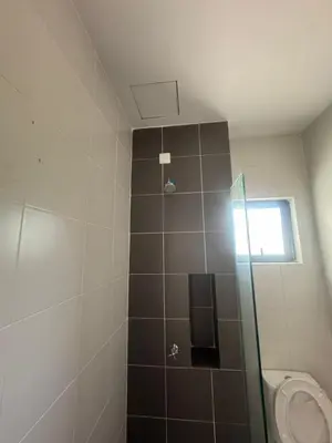 a bathroom with a shower with a toilet and a window at Raub Colonial 208 Homestay in Raub