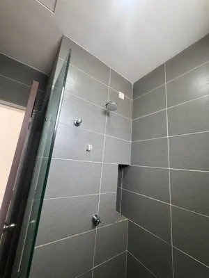 a bathroom with a shower with gray tiles at Raub Colonial 208 Homestay in Raub