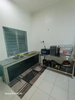 a kitchen with a counter and a sink in a room at Rizqullah Homestay Ipoh in Ipoh