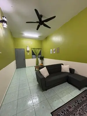 a living room with a couch and a ceiling fan at Wawa Homestay Ipoh in Ipoh