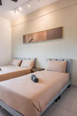 two beds in a hotel room with avertisement for at Serene Japandi & Zen Family Retreat 2-7 pax with Comfortable Living Space in Tanah Rata