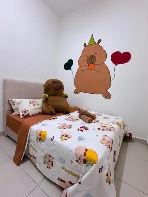 a bedroom with a bed with a hello kitty sticker on the wall at Pantai Remis Capybara House in Pantai Remis