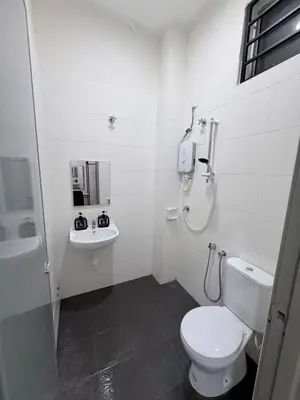 a white bathroom with a toilet and a sink at Pantai Remis Capybara House in Pantai Remis