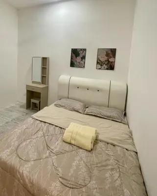 a bedroom with a large bed with a blanket on it at NN Homestay Tasek Gelugor in Kampong Selamat