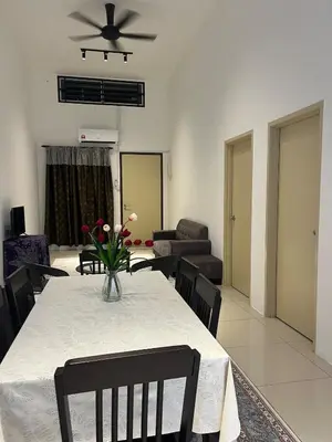 a dining room with a table with a vase of flowers on it at NN Homestay Tasek Gelugor in Kampong Selamat