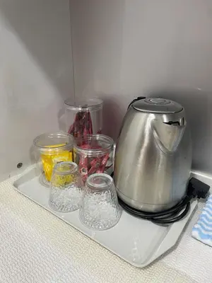 a tea kettle and bowls on a tray in a refrigerator at NN Homestay Tasek Gelugor in Kampong Selamat