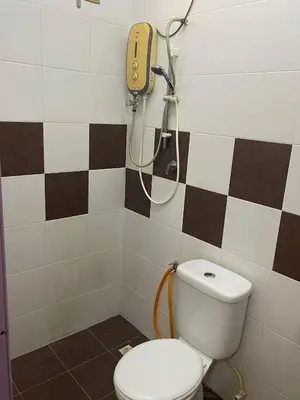 a bathroom with a toilet and a phone on the wall at happy home in Padang Serai