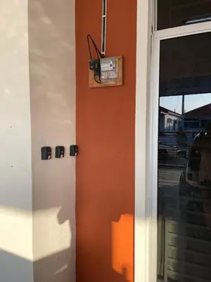 a door to a building with an orange wall at happy home in Padang Serai