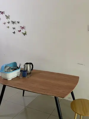 a wooden table with flowers on a wall at happy home in Padang Serai